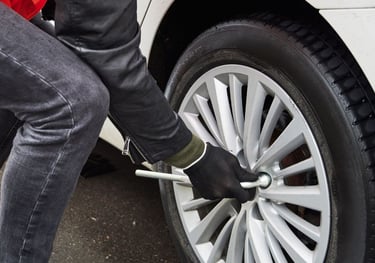 a person standing on a tire with a wrenet