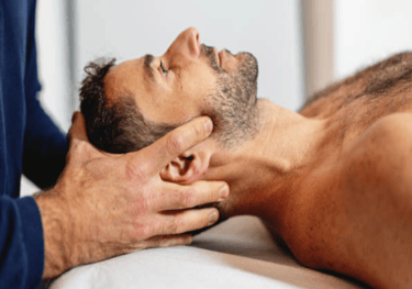 Trattamento cranio sacrale su uomo nudo