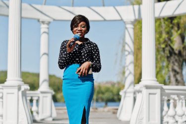 a woman reporter in a polka dot shirt and skirt