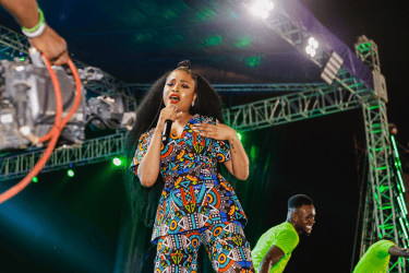 a woman sing on stage at a concert