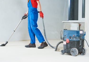 After building cleaning. a man in overalls and overalls cleaning a floor