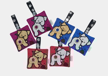 Colorful dog-themed keychains featuring plush designs, printed straps, and an embroidered poop bag holder