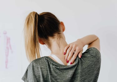 Une femme qui se touche la nuque car elle a une douleur cervicale