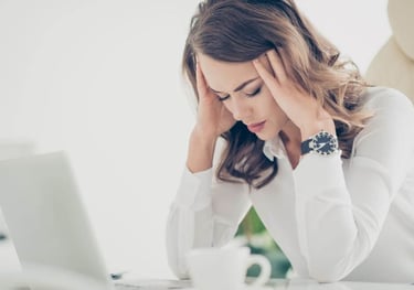 une femme qui se tient la tête car elle a une migraine