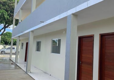 Modern multi-story apartment building with white tile walkways and dark wood doors.