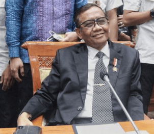 a man in a suit and tie smiling at the camera