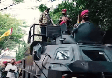 a military vehicle with a man in a pink hat