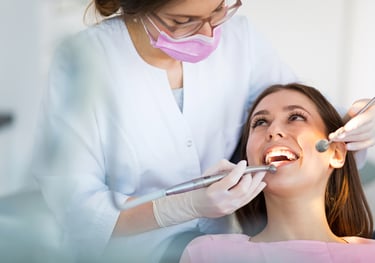A dentist examining a patient’s teeth with advanced dental equipment in a clinic.