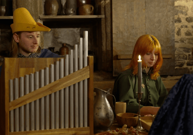 Un musicien joue sur un orgue portatif dans une taverne. Oganetto
