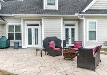 a stamped concrete patio with a patio furniture set up