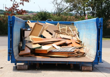 Sperrmüll, hauptsächlich Holz, in einem großen blauen Container