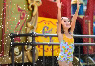 a young girl in a swimsuit is playing in the water