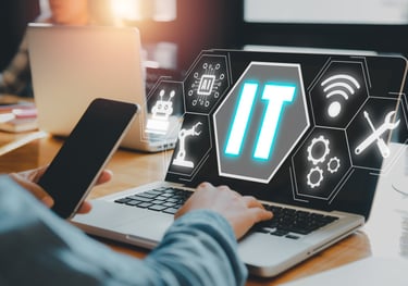 a person sitting at a laptop computer with a laptop and a phone