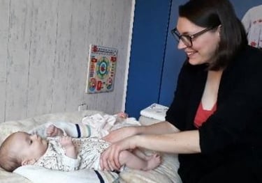 femme massant les jambes de son bébé