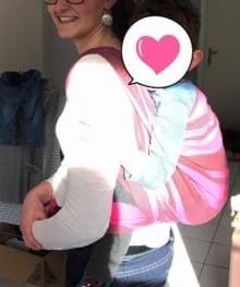 femme souriante portant son bébé sur le dos