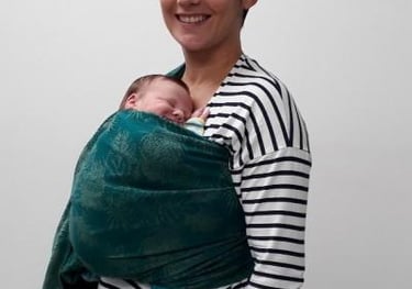 femme souriante portant son bébé sur le ventre