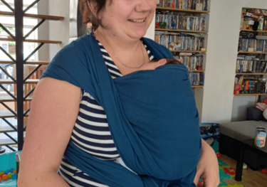 femme portant son bébé en écharpe bleue