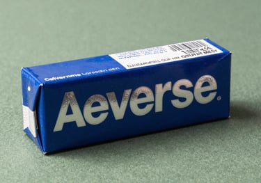A reverse tuck end carton with vibrant blue and silver foil lettering, resting on a textured sage green background in a high-quality studio setting.