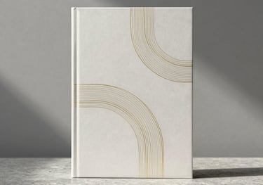 A minimalist book cover sitting on a simple stone plinth. The cover design is abstract and elegant, featuring subtle gold foil lines. Background is a soft grey wall with architectural shadows.