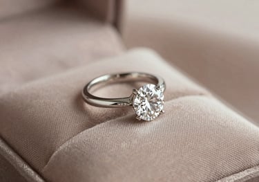 An elegant photograph of a custom-designed diamond engagement ring presented on a soft taupe silk cushion, illuminated by soft, natural light.