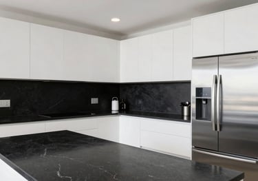 A wide shot of a modern Miami kitchen with white cabinetry, black stone countertops, and sleek stainless steel integrated appliances, bright and clean photography.