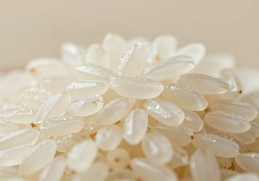 A macro shot of premium long-grain rice. The lighting is soft and professional, highlighting the ivory color and uniform shape of the grains against a #8BA89D background.