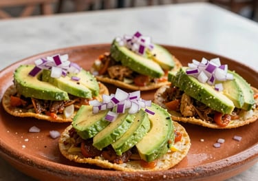 A professional food photography shot of several gourmet seafood tostadas topped with fresh avocado slices and picked red onions. The dish is presented on a handmade terracotta platter in a bright North American / Mexican-American patio setting.