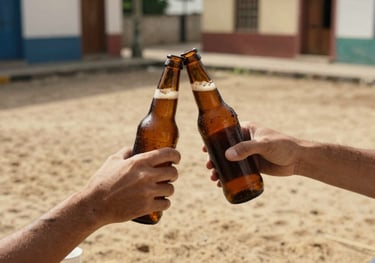 An overhead shot of two friends clinking amber-colored craft beer bottles in a South American / Brazilian urban courtyard, warm sand light.