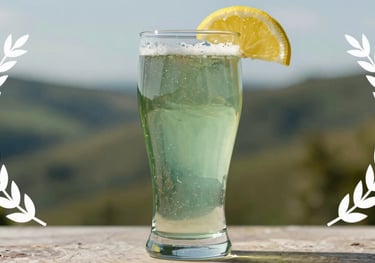 A hazy wheat beer served in a tall glass with a lemon slice, the sage green colors of the foothills reflected in the glass, bright natural lighting.