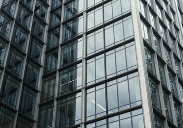 Detail shot of architectural steel and glass in a luxury corporate headquarters, representing strength and transparency. Global / High-end corporate.