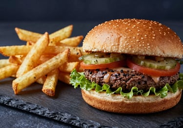 A delicious burger and a side of golden fries on a slate board. The lighting is warm, emphasizing a 'like home' feel with deep midnight indigo accents.
