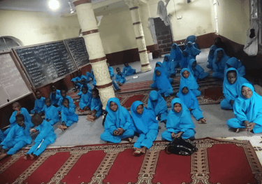 Children in blue uniforms attending mosque-based Qur’an and Islamic education for new Muslims – Sier