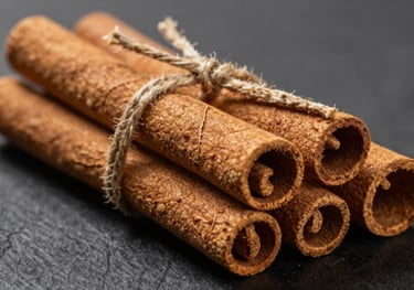 Sticks of high-quality Ceylon cinnamon tied with a simple string. The lighting highlights the thin, layered bark and the delicate tan color of the spice.