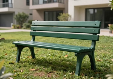 A sleek, dark green garden bench made from recycled plastic, placed on a manicured lawn within a modern South Asian residential complex.