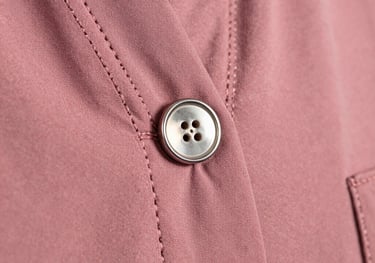 Detailed shot of a silver button and neat stitching on a dusty rose abaya. Focus is on the craftsmanship and high-quality finishing.