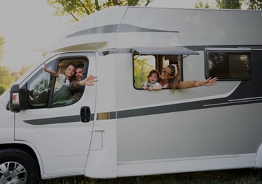 a family of four people are sitting in a camper van