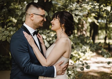 a man and woman standing in front of a tree