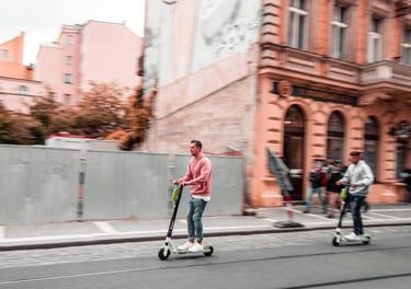 Dos hombres montando en patinete eléctrico con seguro obligatorio Allianz