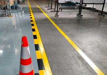 Suelo de una fabrica con las líneas pintadas de amarillo y negro.