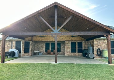 Larged covered patio with a vaulted wooden ceiling.