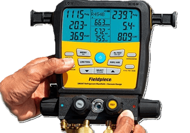 A technician holding a Fieldpiece SMAN digital refrigerant manifold gauge.