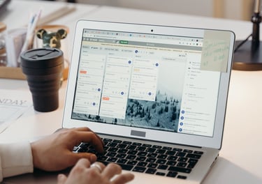 a person sitting at a desk with a laptop and trello