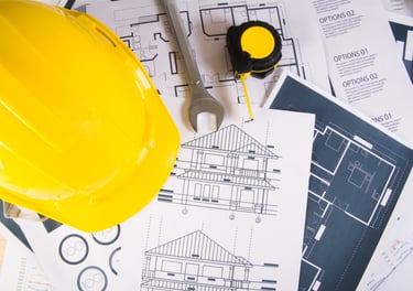 capacete amarelo sobre papéis em uma mesa