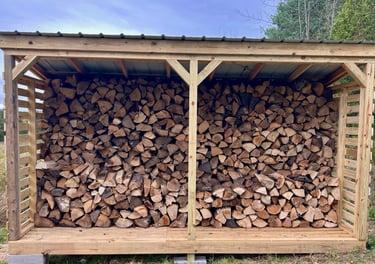 a chord of chopped wood logs stacked on top of each other in a wooden storage shed