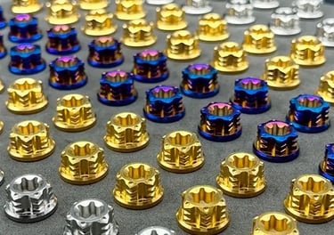 Collection of precision titanium fasteners in various grades and finishes including gold, blue, and 