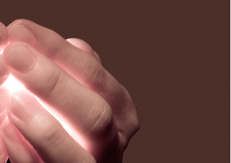 Eine Hand mit die etwas Helles im Inneren umschließt was durch die Finger scheint