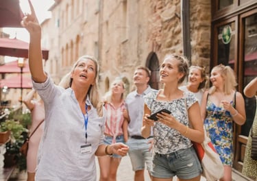 Professional tour guide pointing at architecture for a group of tourists on a walking tour in Europe.