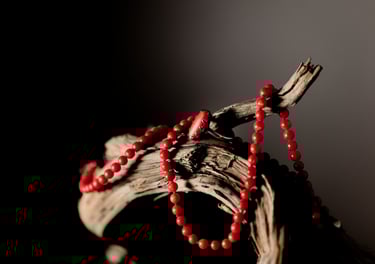 a red beaded necklace with beads on a branch