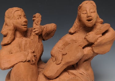 a clay sculpture of a woman playing guitar
