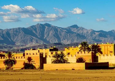 a large building with a mountain in the background